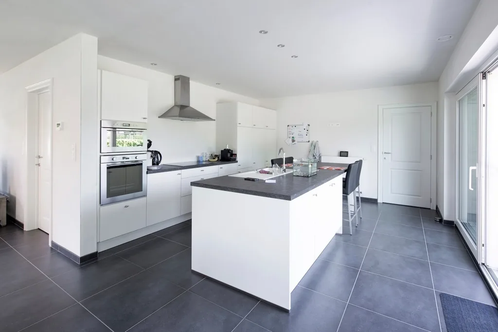 Open kitchen with an island and dark tile floor
