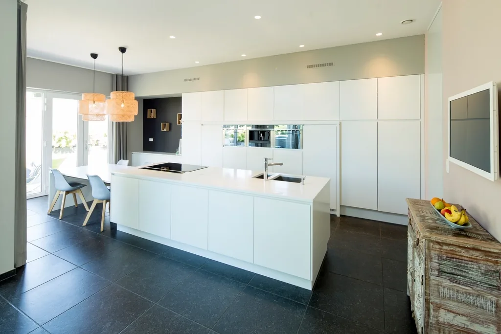 White kitchen with a long island and pendant lights