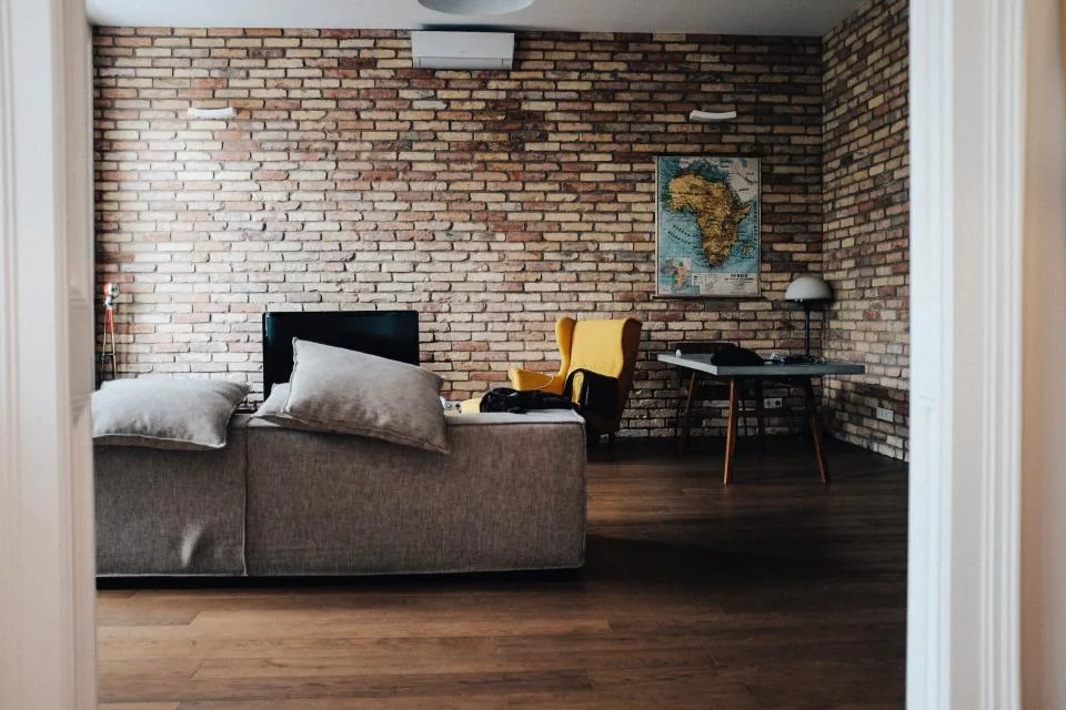 Living room with an exposed brick wall and wood floor